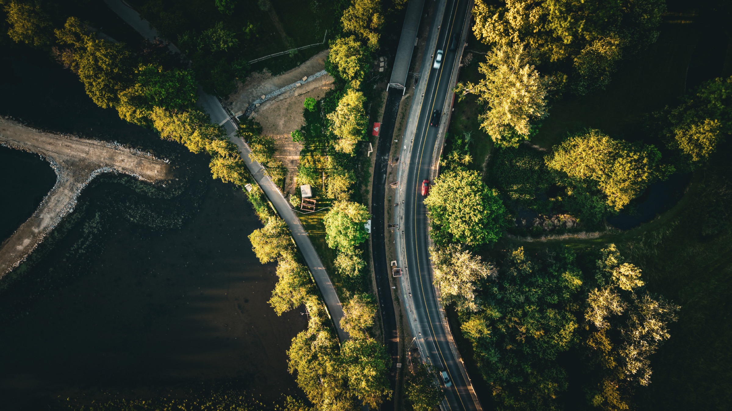 The road crossing at the park boundary — the infrastructure surface where the city begins and the park ends. From nadir the distinction between them almost disappears.