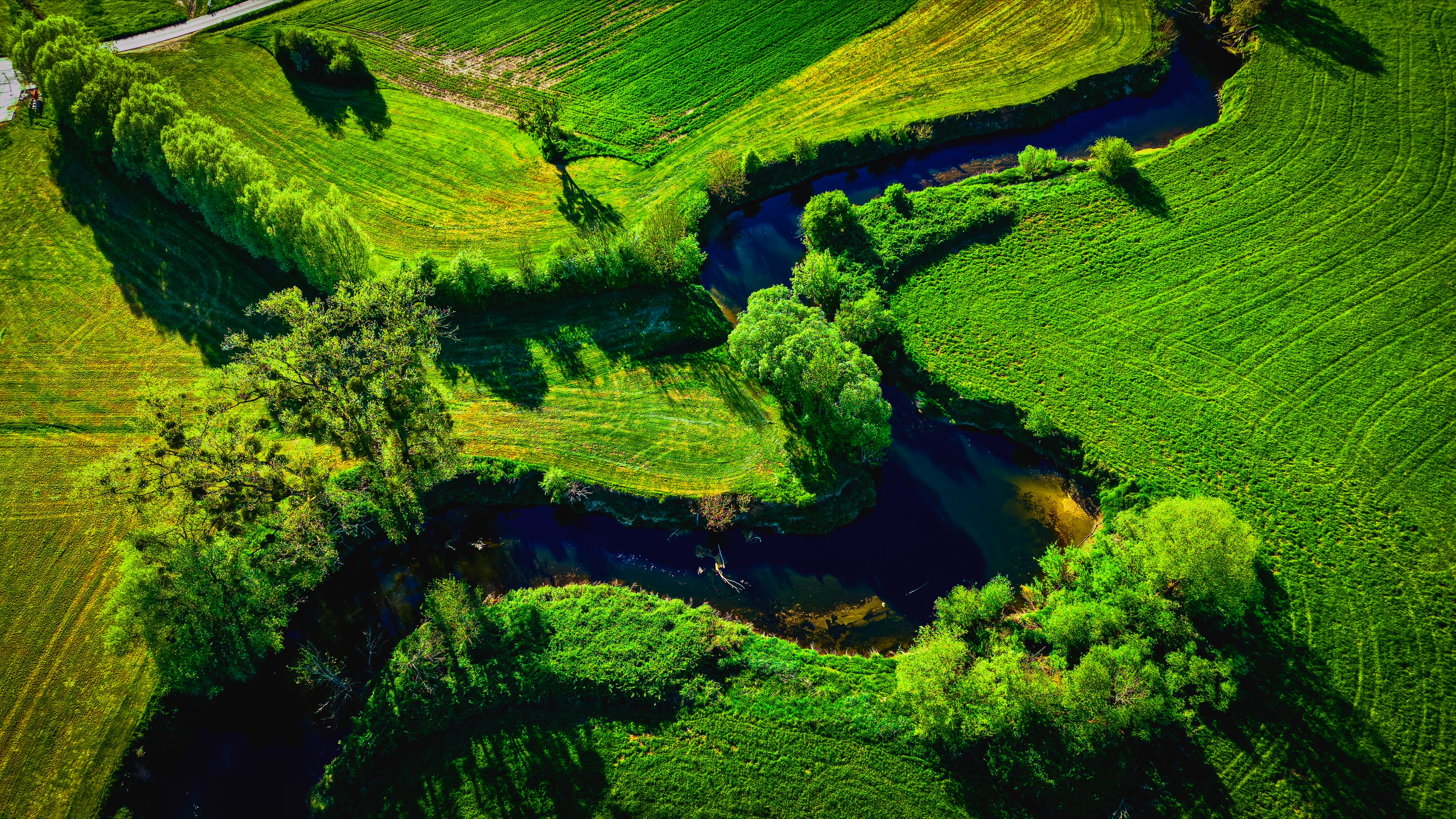 The Alzette river winding through saturated spring fields